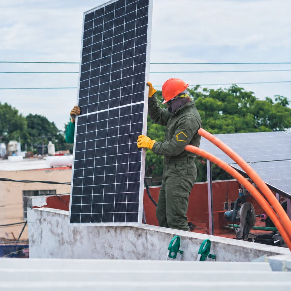 Instalador montando un panel solar sobre una cubierta